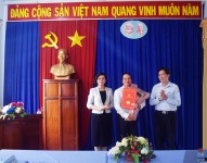 Đồng chí Bùi Quốc Bảo trao quyết định điều động viên chức và đồng chí Trần Tuyết Minh tặng hoa chúc mừng đồng chí Hà Văn Kiên tại buổi Lễ